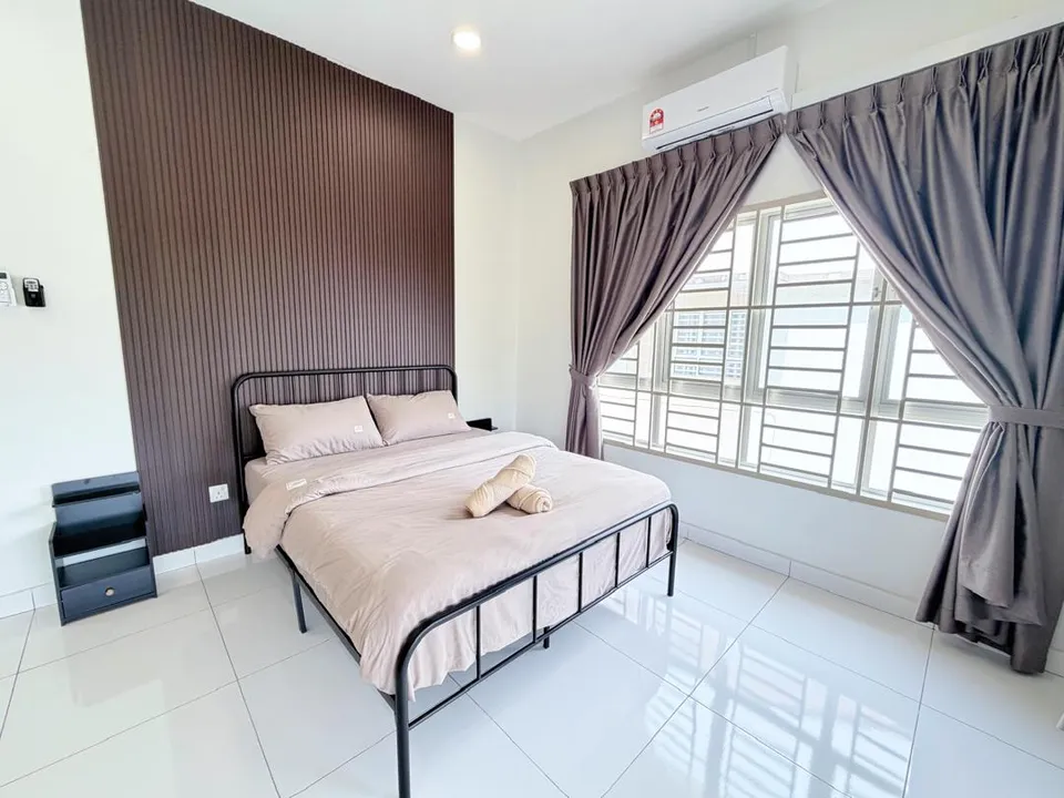 Bedroom with a neatly made double bed, bedside table, and warm curtains